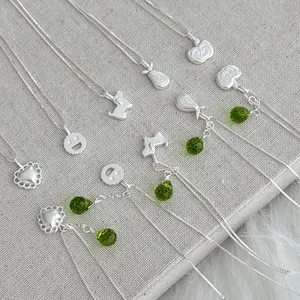 Detailed view of various S925 silver necklaces with heart apple charms and green beads