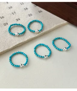 Detailed view of new Chinese style elastic turquoise bead rings with silver gourd charm