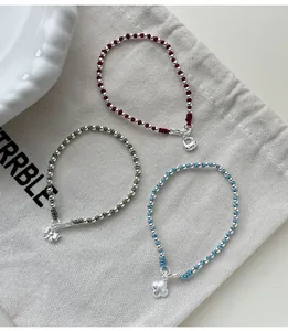 Detailed view of S925 silver beaded bracelets with colorful cords and charms