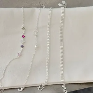 Detailed view of S925 silver bracelet collection featuring flower and butterfly charms