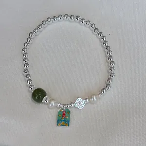 Detail of S925 silver beaded bracelet with jade bead and pearl charms
