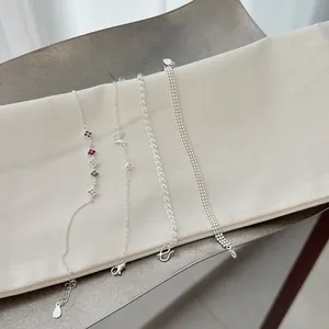 Detail view of various s925 silver chain bracelets for stackable wear