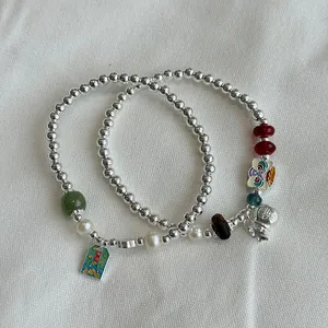 Detail view of S925 silver beaded bracelets with pearls and traditional lucky charms.