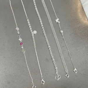 Variety of S925 silver bracelets with charms including clover, flower, butterfly and pearl.