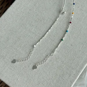 Close-up view of a s925 silver bracelet featuring colorful enamel beads and heart charm