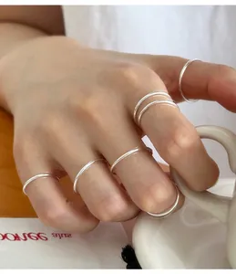 Detailed view of minimalist 999 sterling silver thin plain band rings worn on a hand