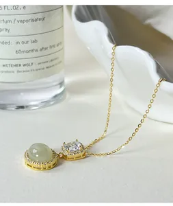 Macro view of S925 silver necklace with oval green jade and square clear gemstone