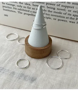 Minimalist 999 sterling silver smooth band rings set displayed on a cone stand