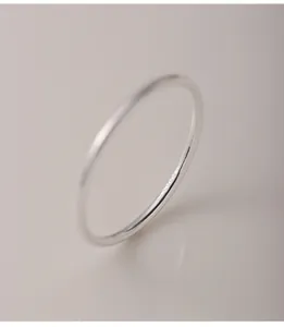 Macro view of 999 sterling silver plain band ring featuring a minimalist and sleek design