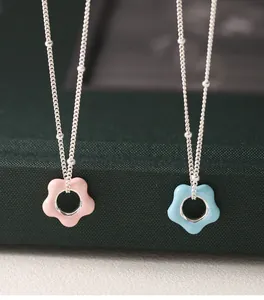 Detailed view of pink and blue enamel flower pendants on 925 silver satellite chains.