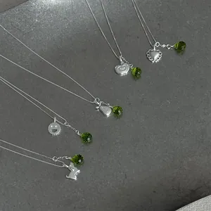 Detailed view of various S925 silver necklaces featuring cute charms and green crystal beads.