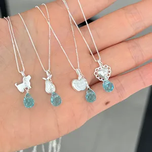 Detail of S925 silver necklaces with heart and fruit pendants and blue crystals