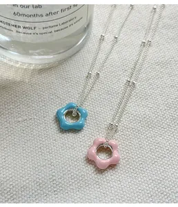 Detailed macro shot of 925 silver enamel flower necklaces in pink and blue