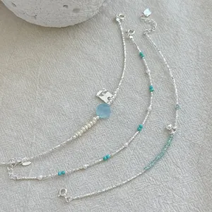 Detailed shot of 925 sterling silver bracelets with pearls and aquamarine gems