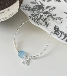 Macro detail of 925 sterling silver bracelet with aquamarine stone and small pearls