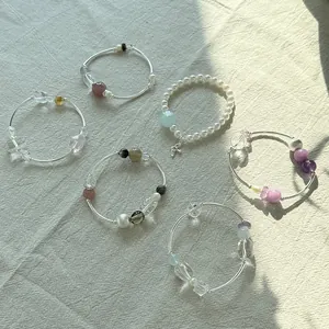 Pulseras elegantes de plata 925 con cristales de colores y perlas sobre lino.