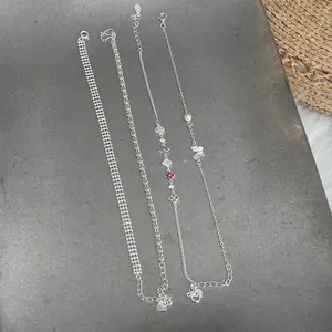 Detailed view of four S925 silver bracelets with colorful charms and unique chain links