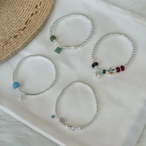 Detailed view of four different S925 sterling silver beaded bracelets with charms