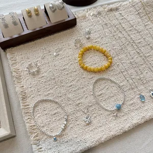 Elegant collection of S925 silver beaded bracelets and necklaces displayed on a woven mat