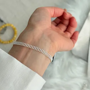 Close-up view of a delicate S925 silver beaded mesh chain bracelet on a wrist.