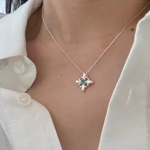 Primo piano di una collana con ciondolo a iris in argento S925 e zircone verde brillante