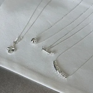 Detail view of 925 sterling silver necklaces with clover and dachshund pendants