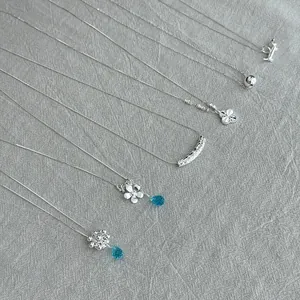 925 sterling silver necklace collection with assorted minimalist pendants on textured fabric