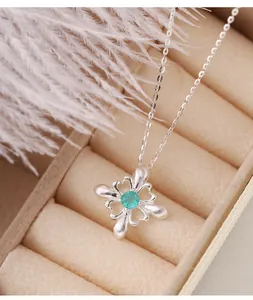 Dettaglio di un ciondolo iris in argento S925 con zircone verde in un portagioie