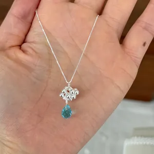 Detailed macro view of 925 sterling silver necklace featuring a light blue teardrop gemstone
