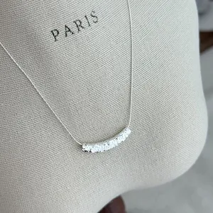 Detail view of a 925 sterling silver necklace with a crushed ice texture curved pendant.