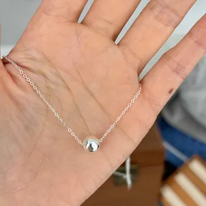 Close-up of minimalist 925 sterling silver necklace with a polished ball pendant