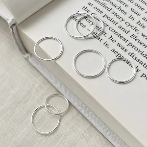 Minimalist S999 sterling silver plain rings for women displayed on an open book background
