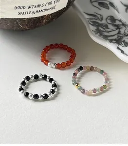 Detailed view of three elastic beaded rings featuring sterling silver and agate gems.