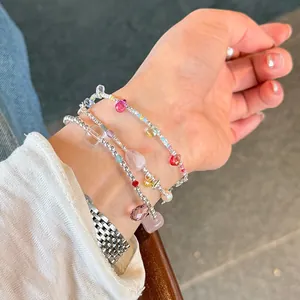Close-up of layered 925 silver beaded bracelets with colorful crystals and pearls on wrist