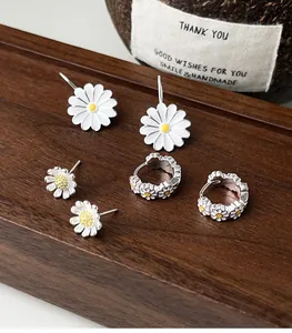 Detalle de un juego de pendientes de margarita en plata de ley 925 con aros.