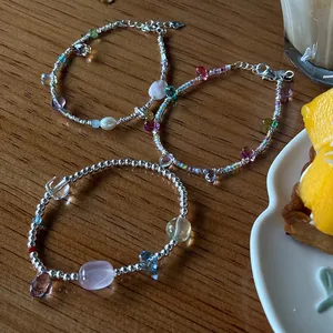 Macro view of 925 sterling silver bracelets with crystals and pearls on a wooden table