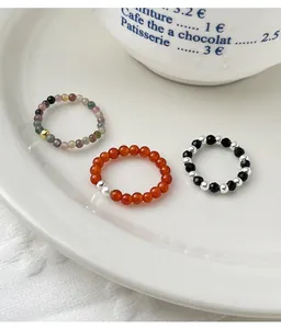 Detail view of colorful tourmaline and red agate beaded rings with silver accents.