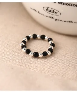 Detailed view of elastic 925 silver bead ring with black faceted gemstones