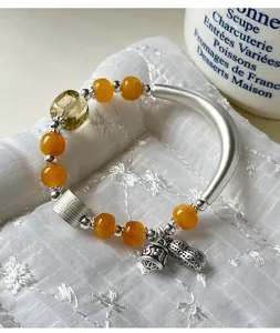 Detailweergave van een 999 zilveren armband met amberen kralen en pinda-hanger.