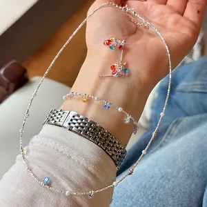 Detail of 925 sterling silver necklace set with colorful zircon on a wrist.