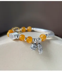 Detailopname van 999 zilveren en amberen kralenarmband met pinda bedeltje