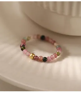 Close-up of handmade multi-color tourmaline bead ring with a gold accent bead