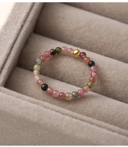 Macro view of a handmade tourmaline bead ring with a single gold accent bead.