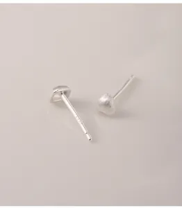 Detailed close-up of matte 990 sterling silver heart and square stud earrings