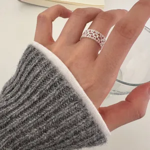 Close-up of a 925 sterling silver lace ring with delicate hollow design and rhinestones