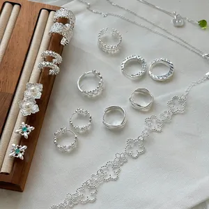 Colección de joyas de plata elegante con intrincados diseños florales de encaje y formas
