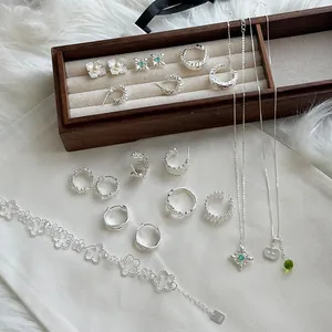 Primer plano del conjunto de joyas de plata S925 con pulsera de trébol y colgantes