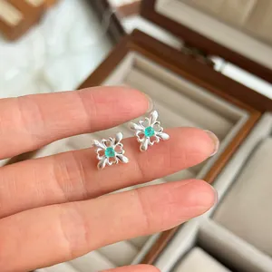 Vista detallada de pendientes de plata S925 con diseño de encaje y piedra verde central