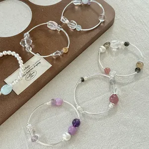 Primer plano de pulseras de plata de ley 925 con cristales de colores y perlas