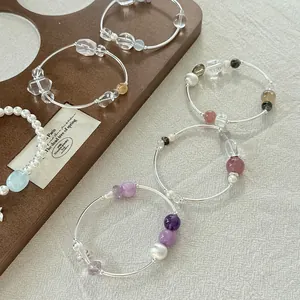 Detalle de pulseras de plata 925 con cristales de colores y perlas de diseño elegante.